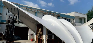 Factory installation photo of the white membrane structure canopy showing the fabricated curved roof system.