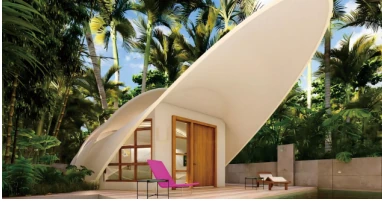 Front view of the membrane structure hotel cabin with a sculptural white canopy surrounded by tropical trees.