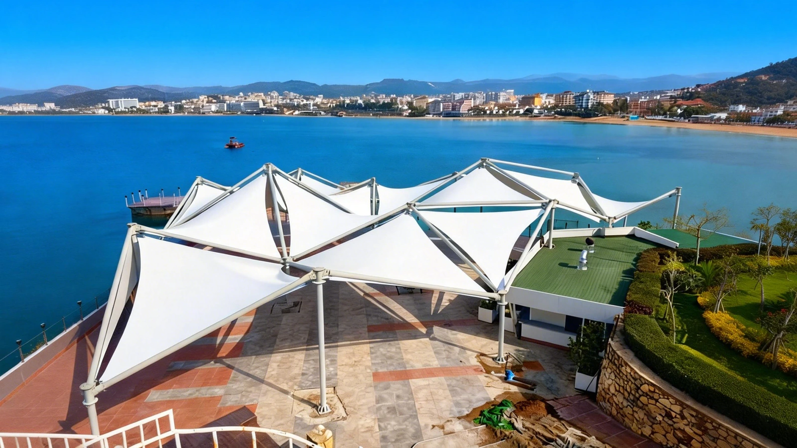 Tensile sail canopies over a waterfront public terrace