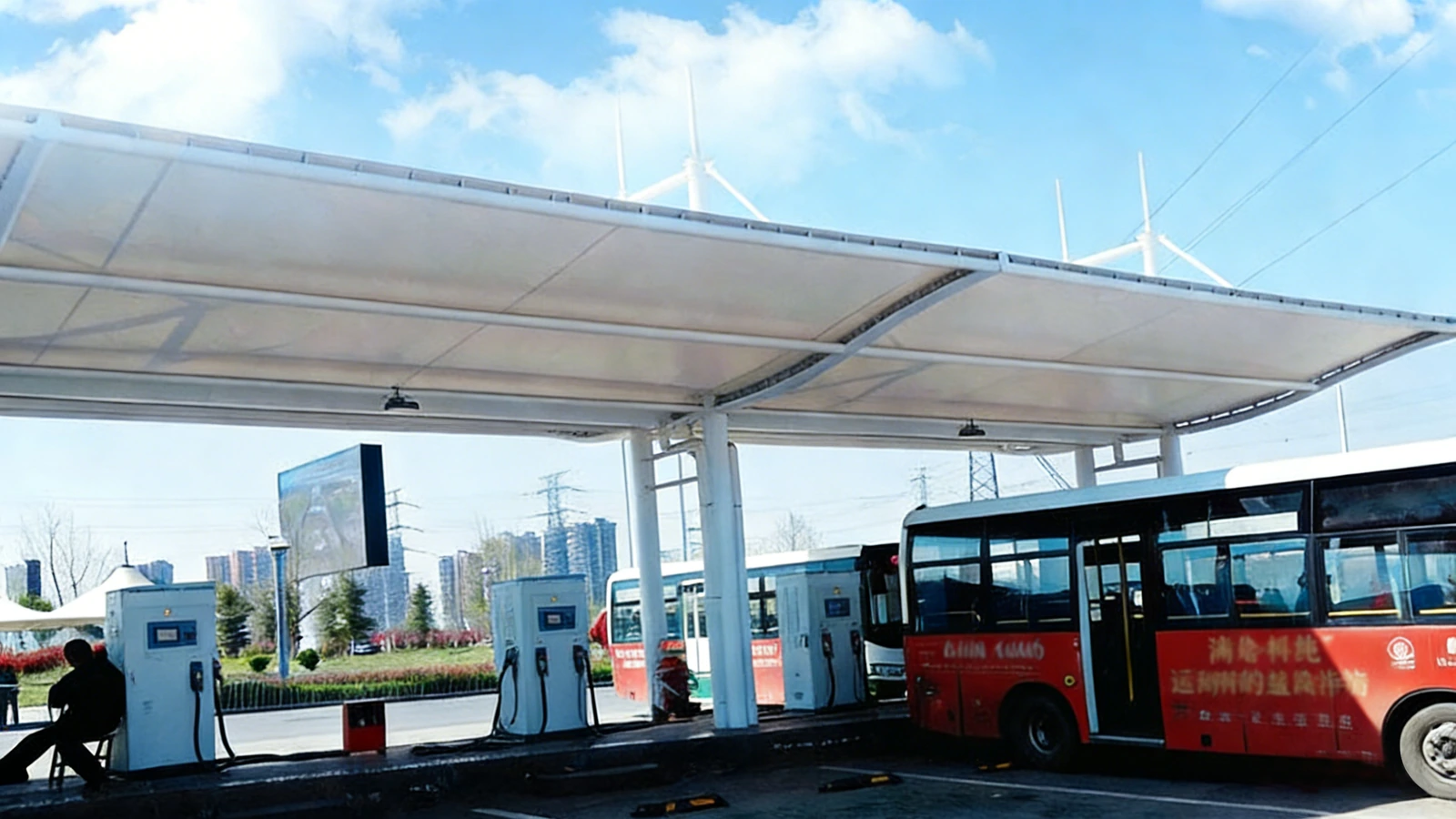 Long flat membrane canopy over electric bus charging bays
