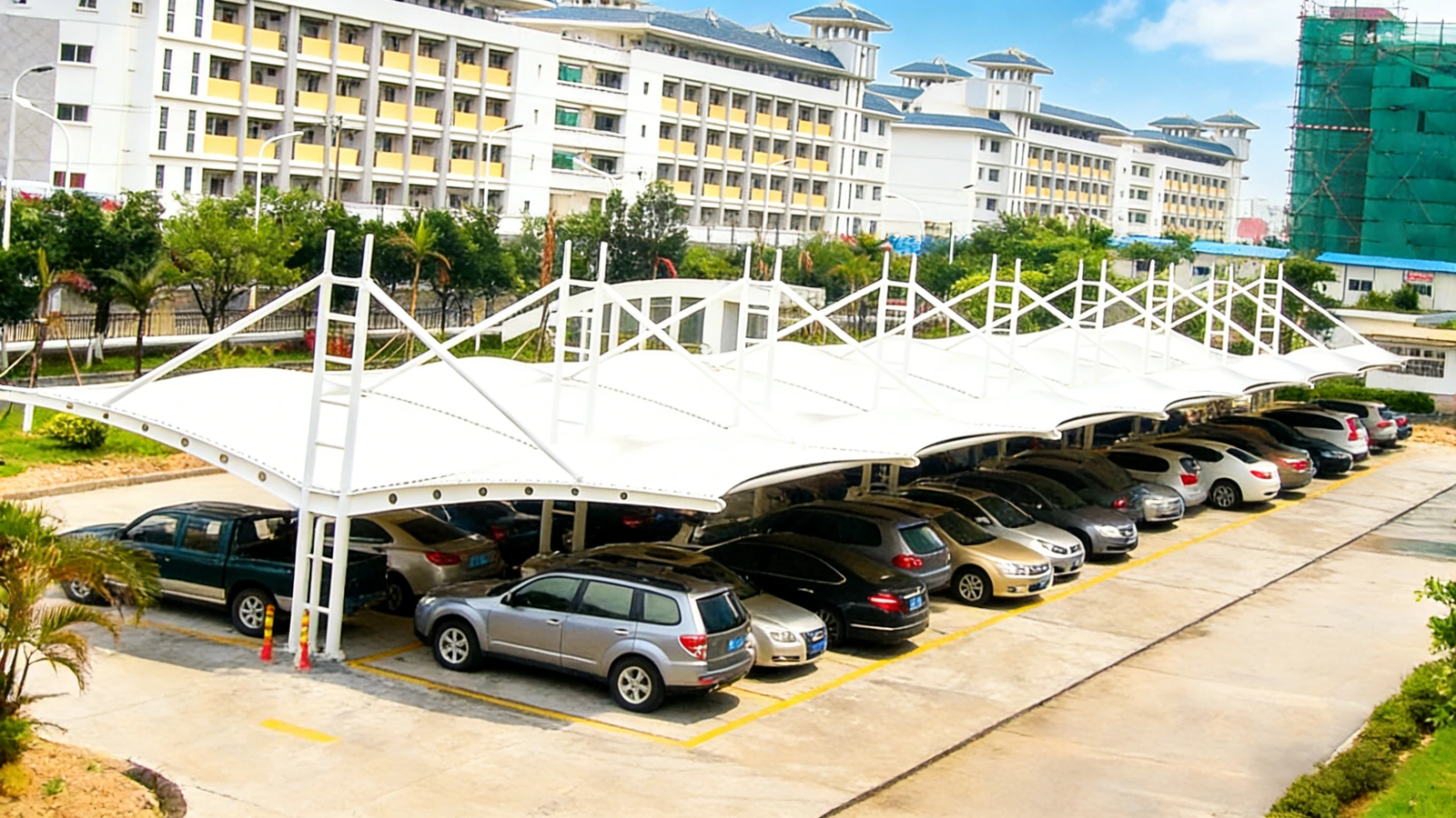 Tensile membrane carport canopies covering a row of parked cars