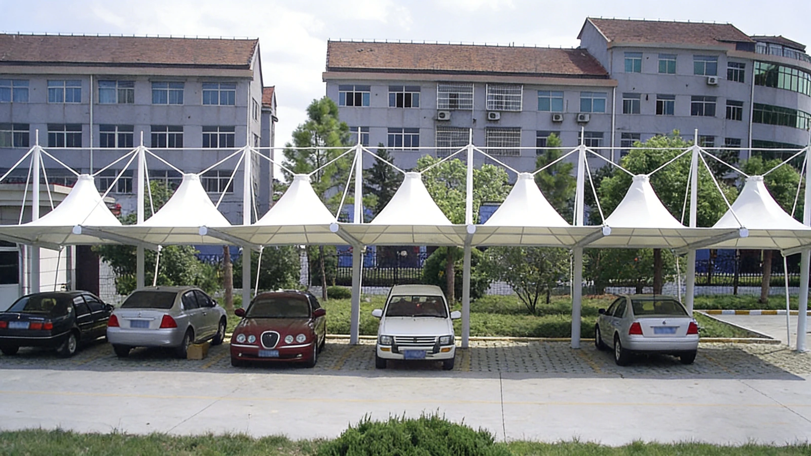 Row of conical tensile membrane carport canopies
