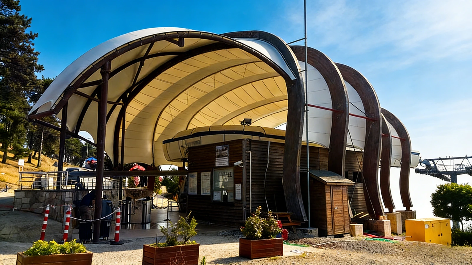 Timber-clad toll booth with a curved tensile membrane roof
